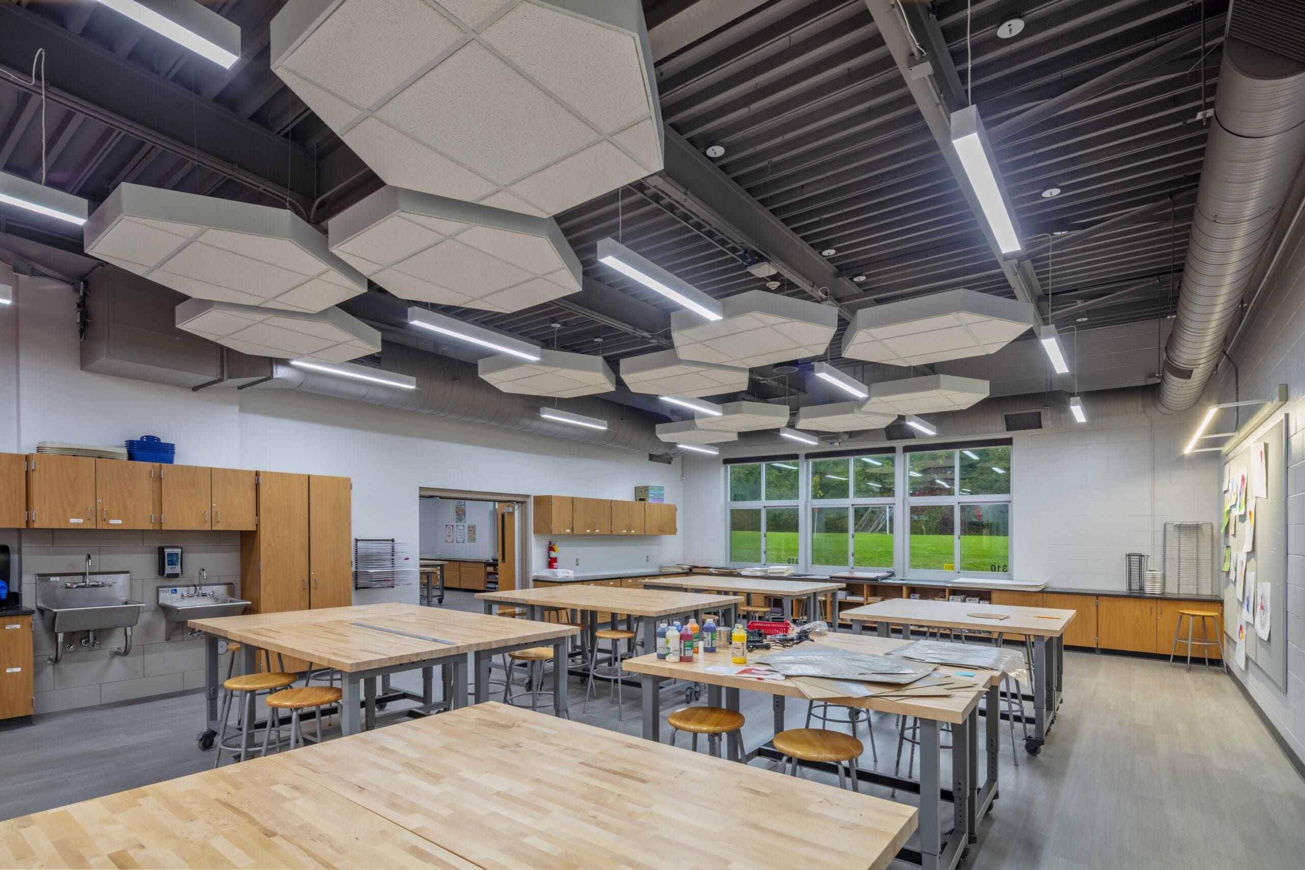 Modern art classroom with workstations and natural lighting.